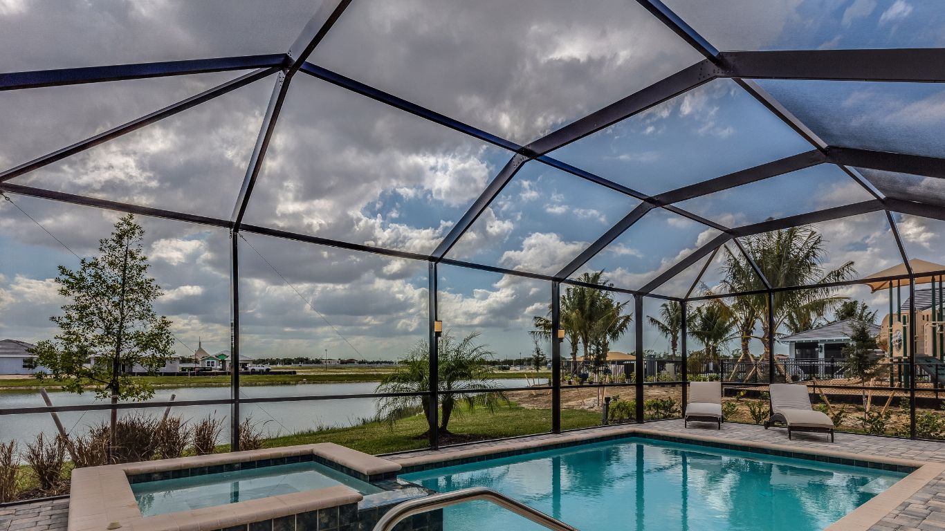 Why Pool Enclosures in Fort Myers FL Make Every Swim More Fun and Less Work Outdoor pool with a screened enclosure in Fort Myers, FL, showcasing the benefits of pool enclosures.